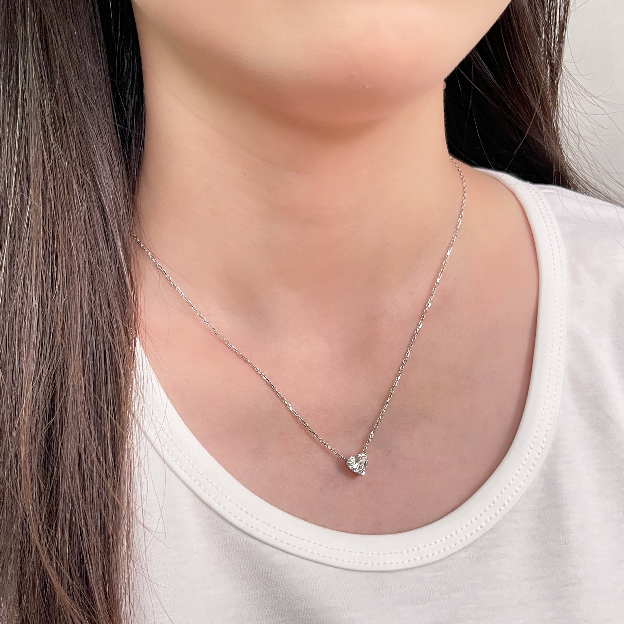 Side-profile view of a model wearing a 1.51 carat heart-shaped lab grown diamond necklace in 18K white gold.