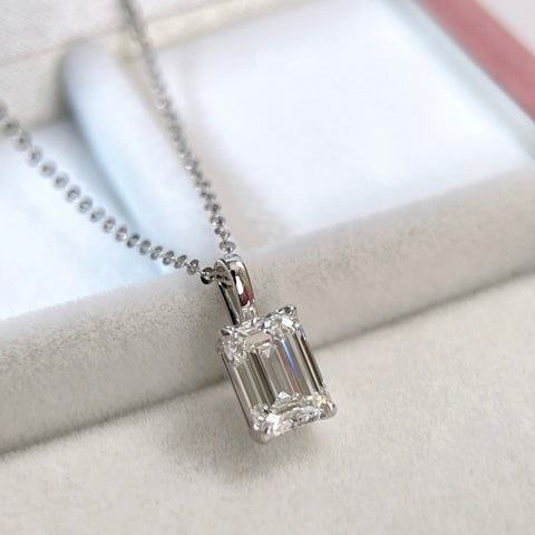 Angled display of a 1.5 ct emerald-cut lab grown diamond 14K white gold pendant styled on a chain