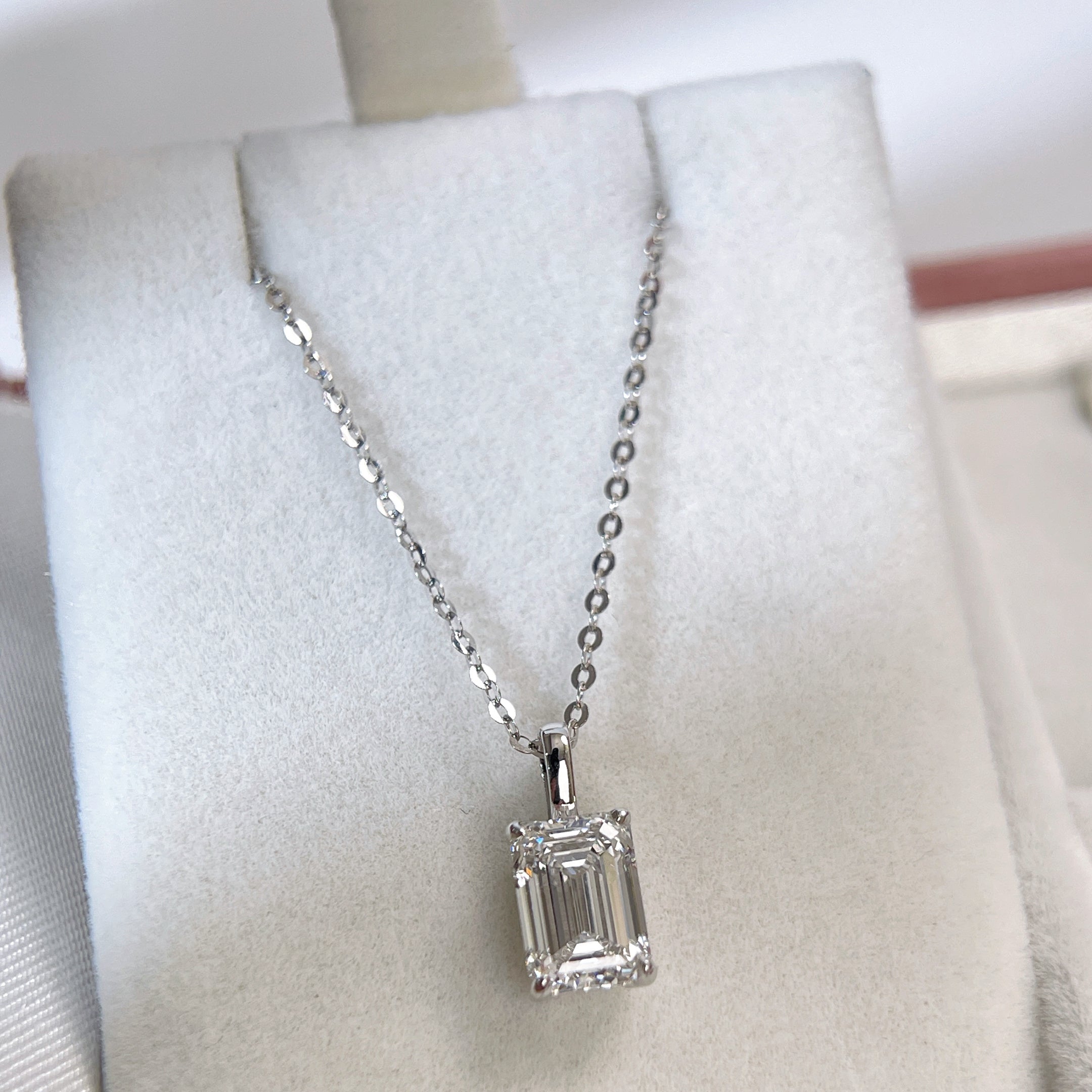 Wide display of an emerald-cut lab grown diamond 14K white gold pendant styled on a chain