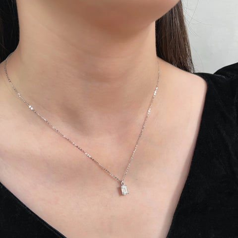 Close-up of a model wearing an emerald-cut lab grown diamond 14K white gold pendant on a chain