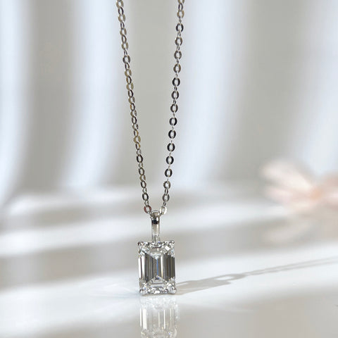 Angled reflective display of an emerald-cut lab grown diamond 14K white gold pendant on a chain
