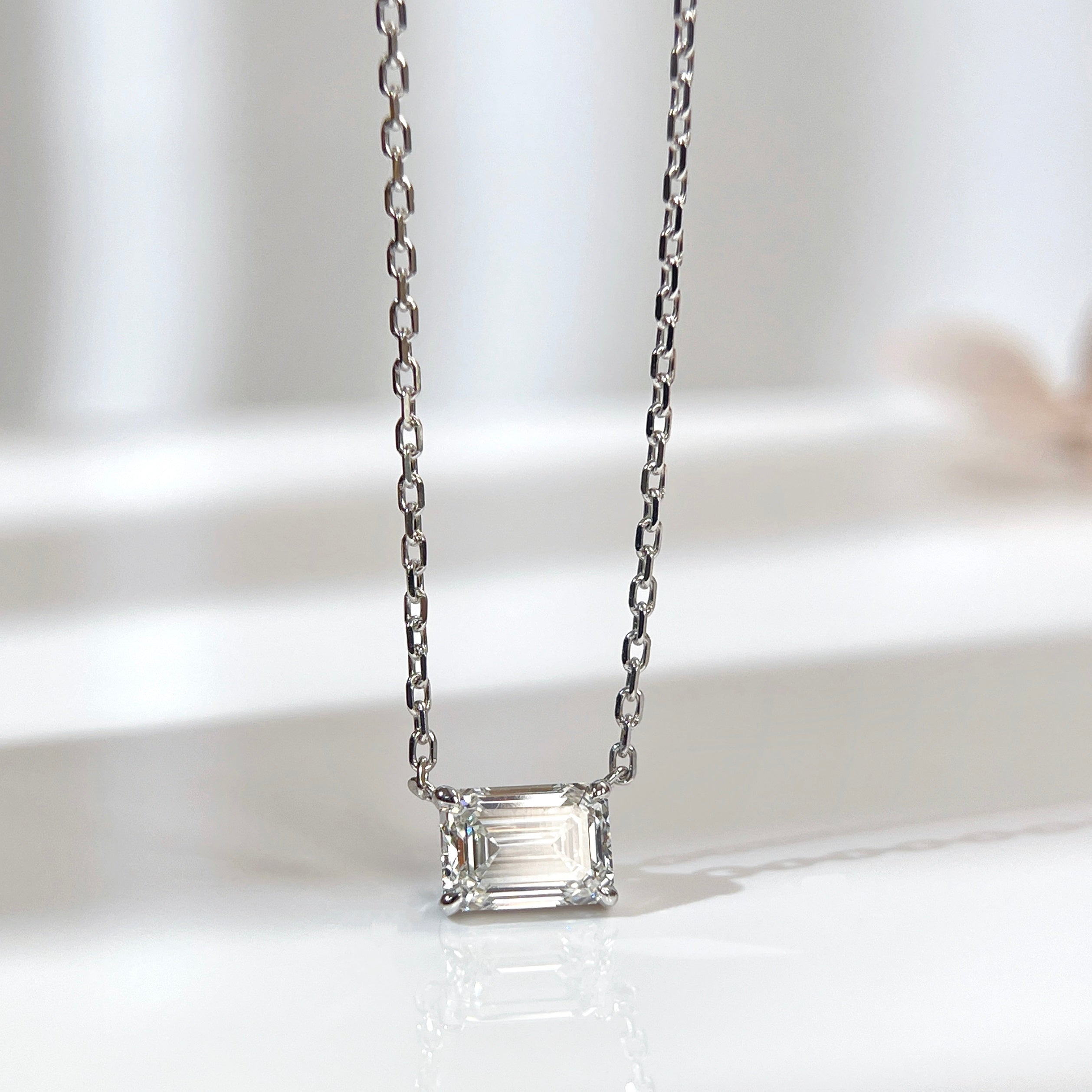 Front view of a 1.5 ct emerald-cut lab grown diamond necklace in an 18K white gold four-prong setting