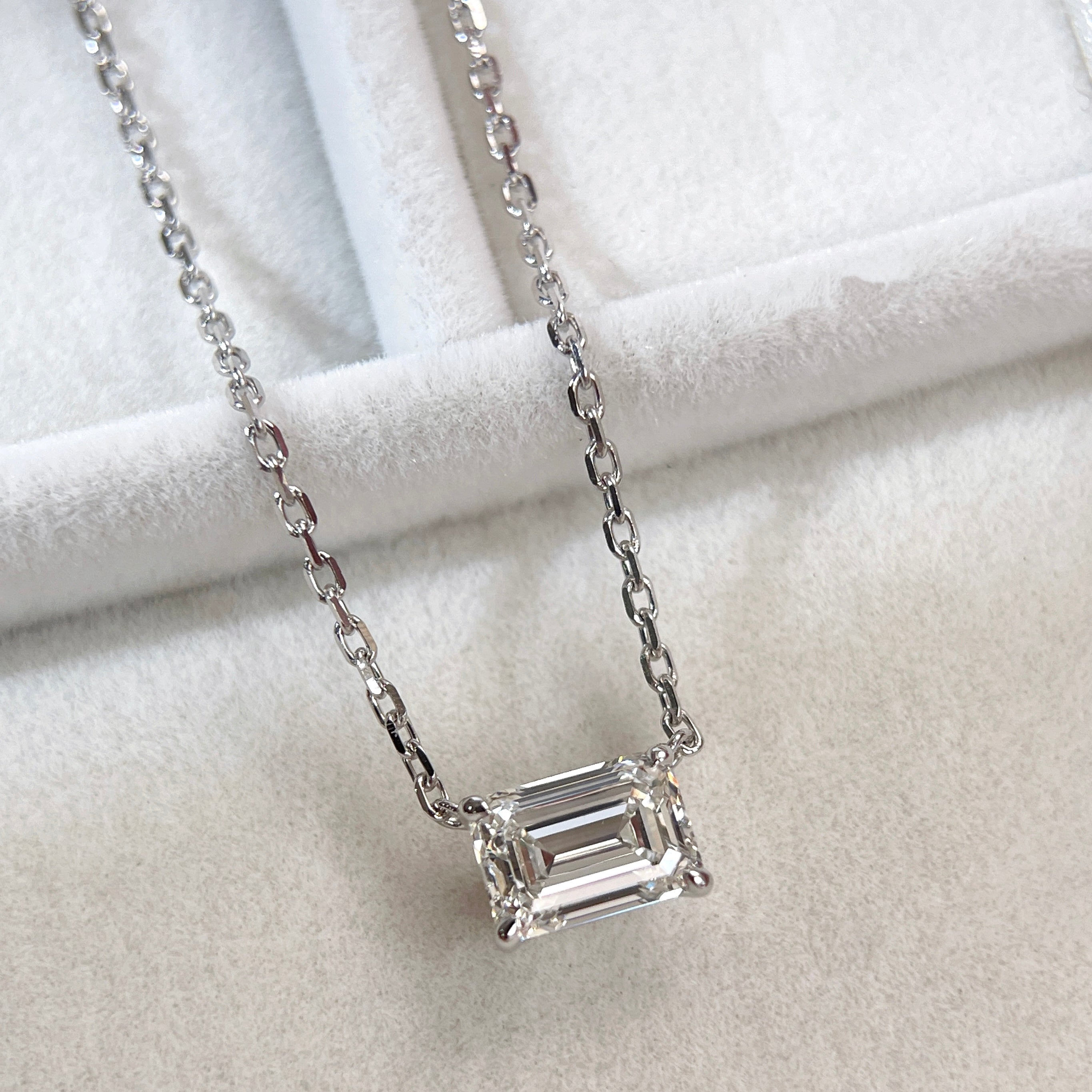 Angled display of a 1.5 ct emerald-cut lab grown diamond solitaire necklace in 18K white gold