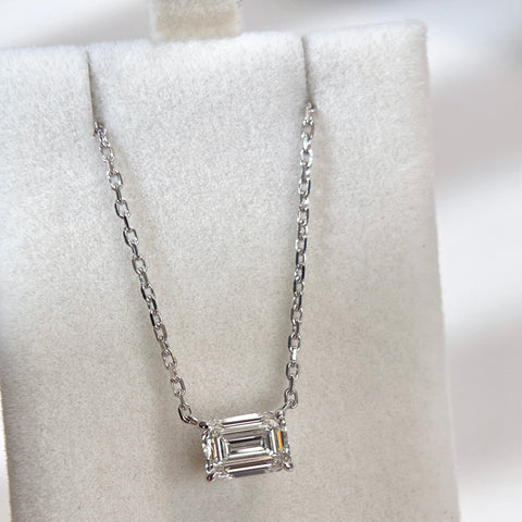 Wide jewelry box display of an emerald-cut lab grown diamond necklace with an 18K white gold chain