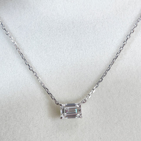 Centered display of a 1.5 ct emerald-cut lab grown diamond four-prong necklace in 18K white gold