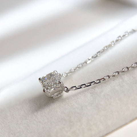 Side view showing the four-prong basket of an emerald-cut lab grown diamond 18K white gold necklace