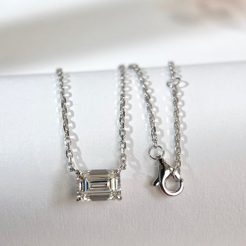 Emerald-cut lab grown diamond necklace with its 18K white gold chain and clasp displayed together