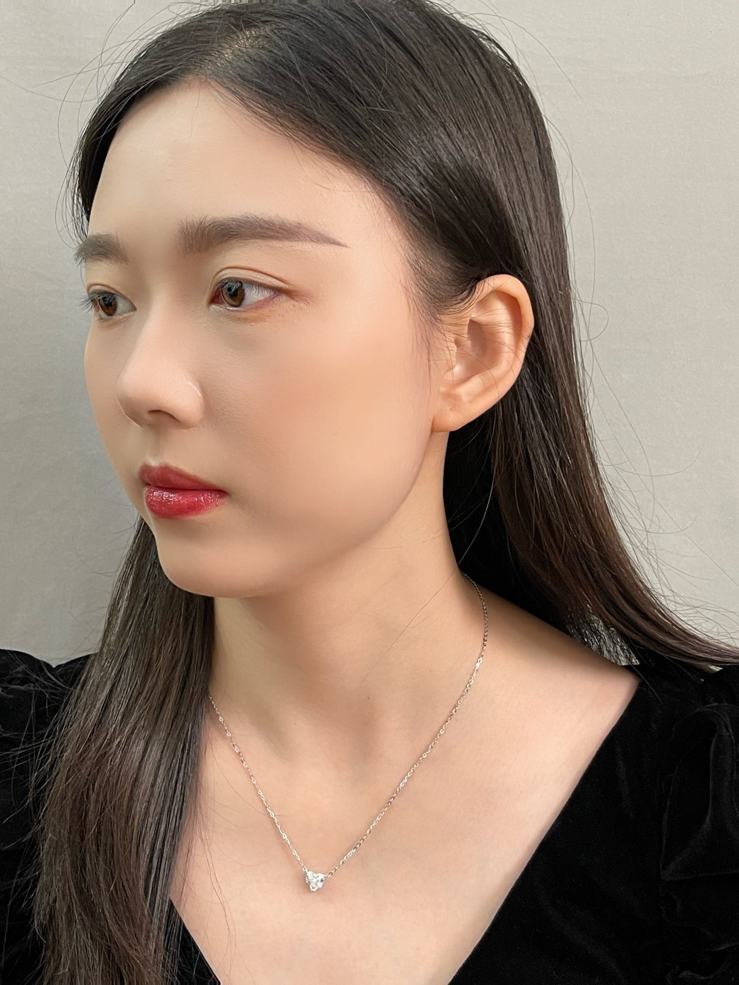 Portrait of a model wearing a 1.5 carat heart-shaped lab grown diamond necklace in S925 sterling silver.