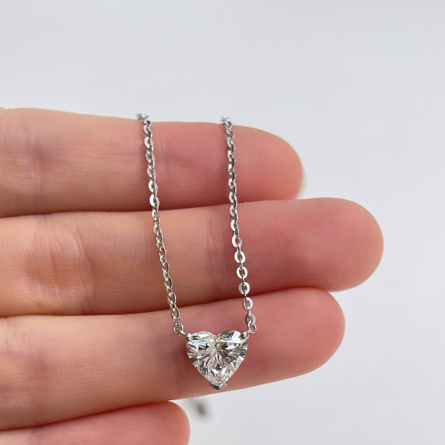 Close-up displayed on a hand: a 1.5 carat heart-shaped lab grown diamond necklace in S925 sterling silver.