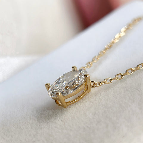 Side view showing the four-prong setting of an oval lab-grown diamond necklace