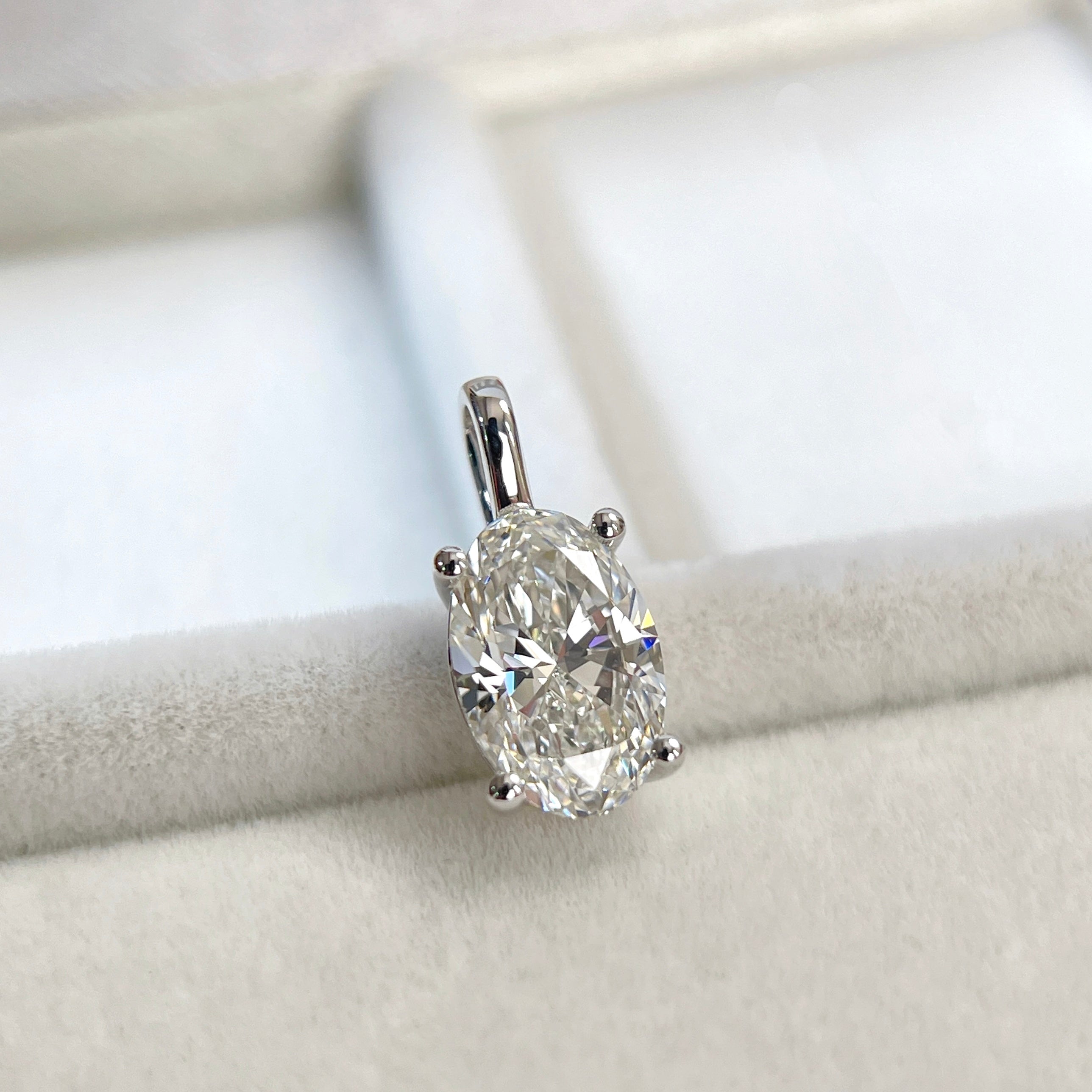 Angled view of an oval lab-grown diamond pendant in 14K white gold