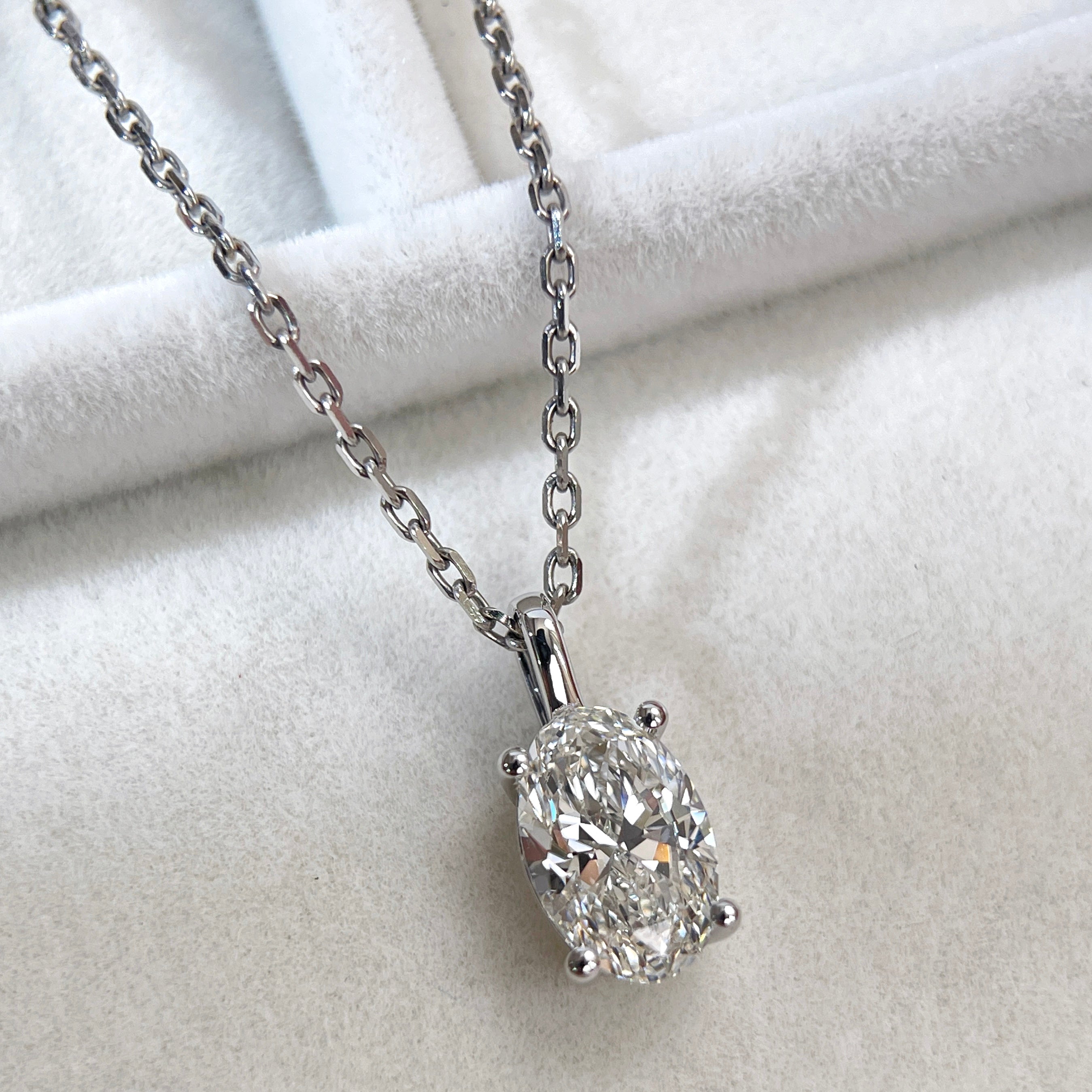 Angled close-up of a 1.5 carat oval lab-grown diamond pendant shown on a chain