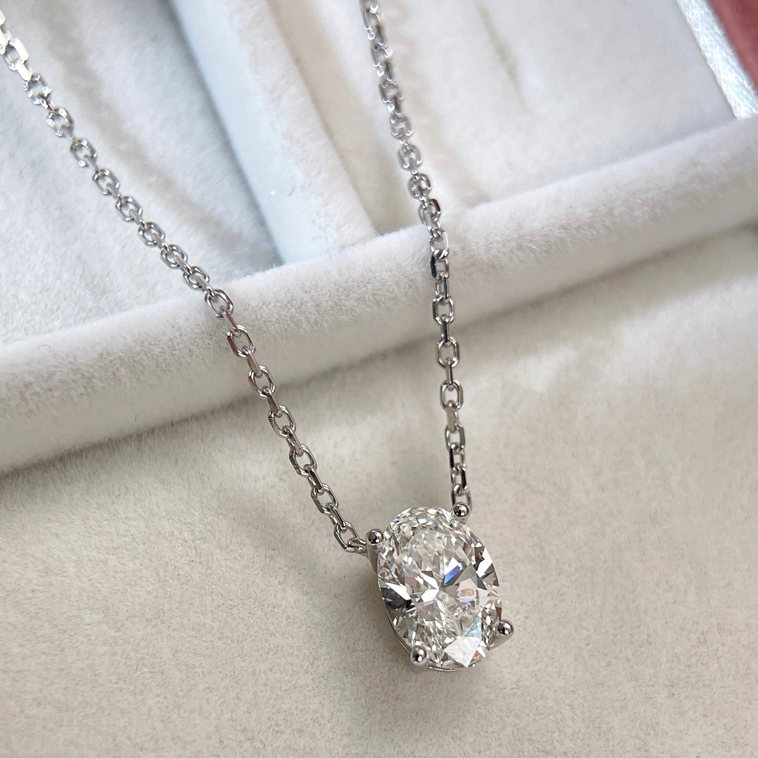 Angled jewelry display of a 1.58 carat oval lab grown diamond necklace in 18K white gold.