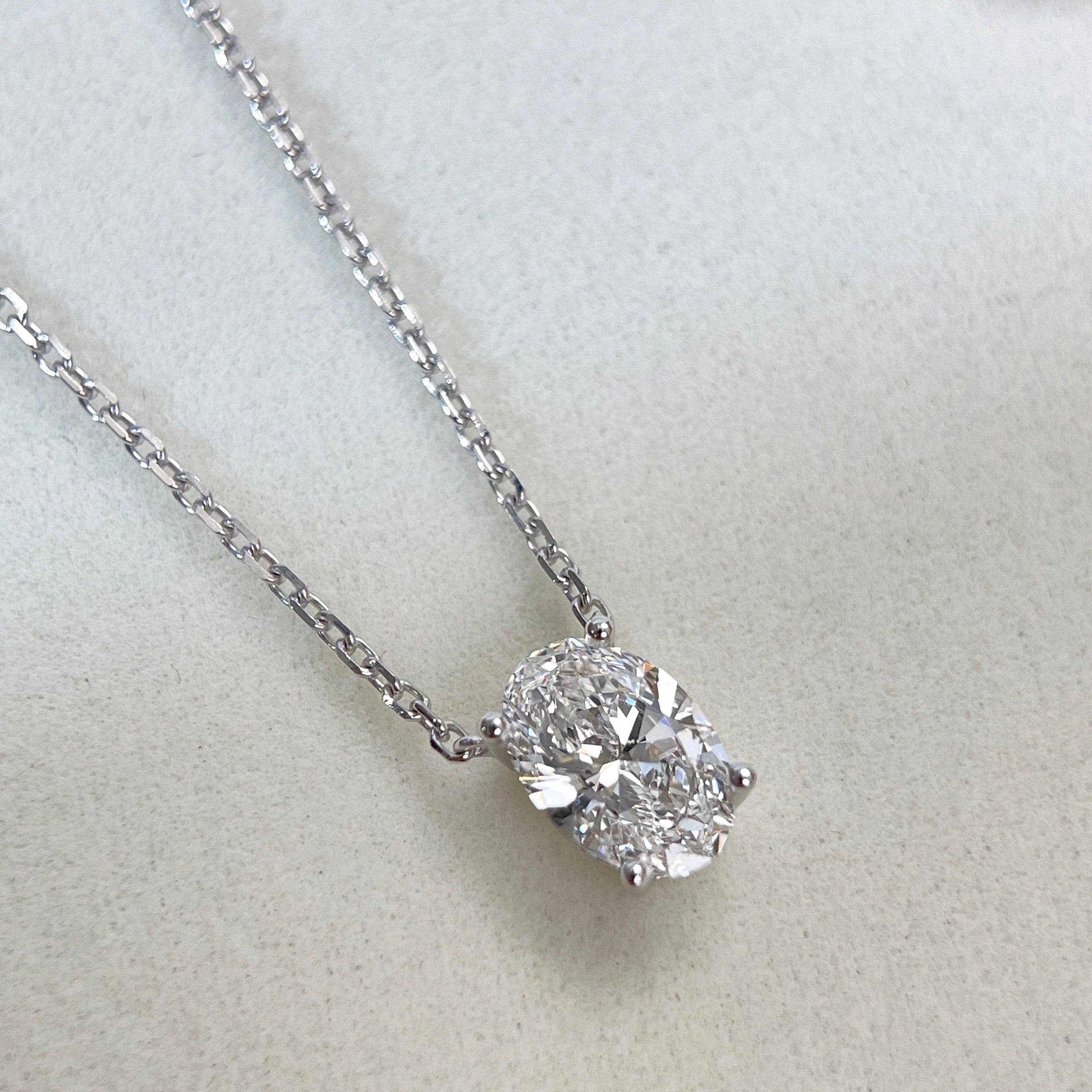 Diamond detail of a 1.58 carat oval lab grown diamond necklace in 18K white gold.