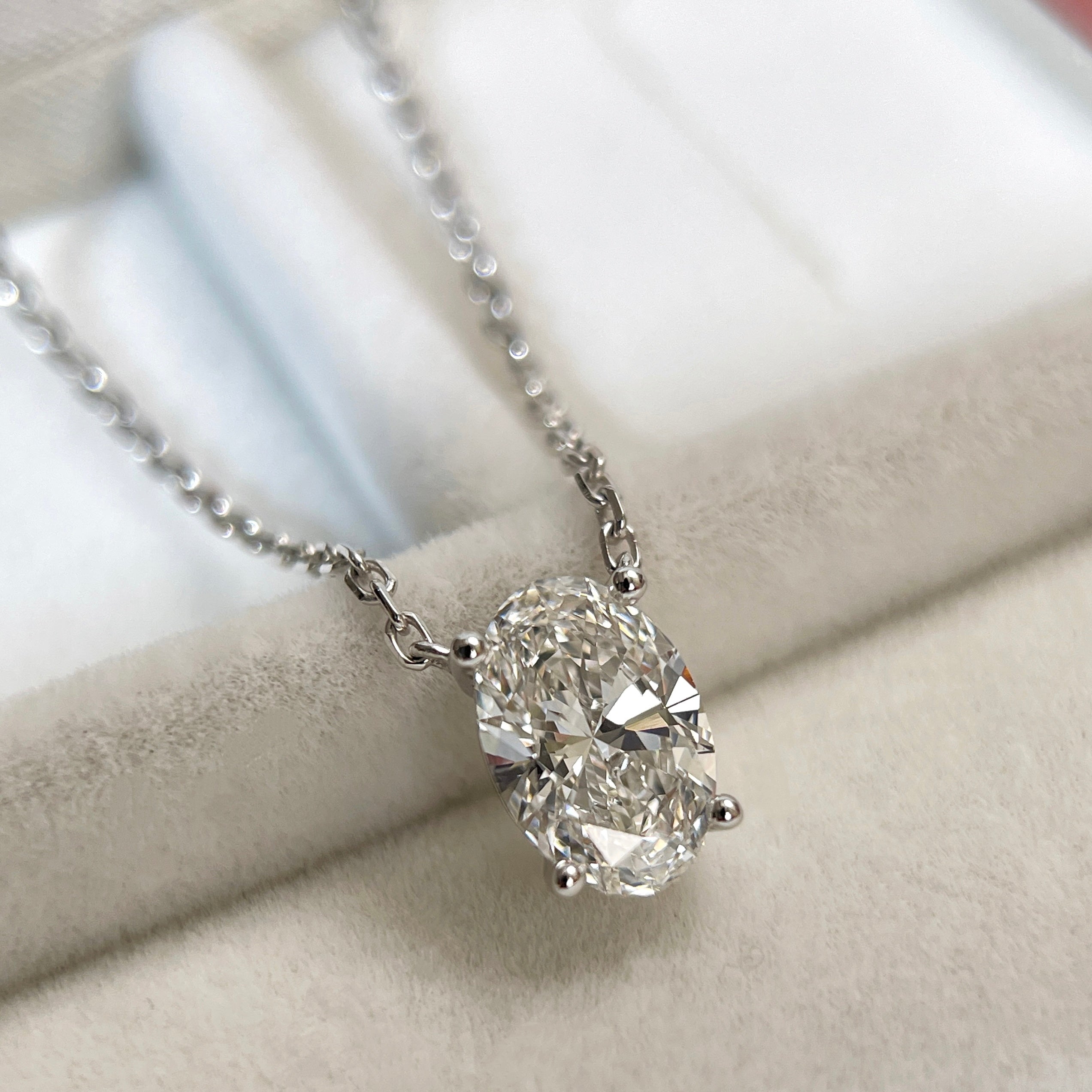 Close-up of a 1.58 carat oval lab grown diamond necklace in 18K white gold.