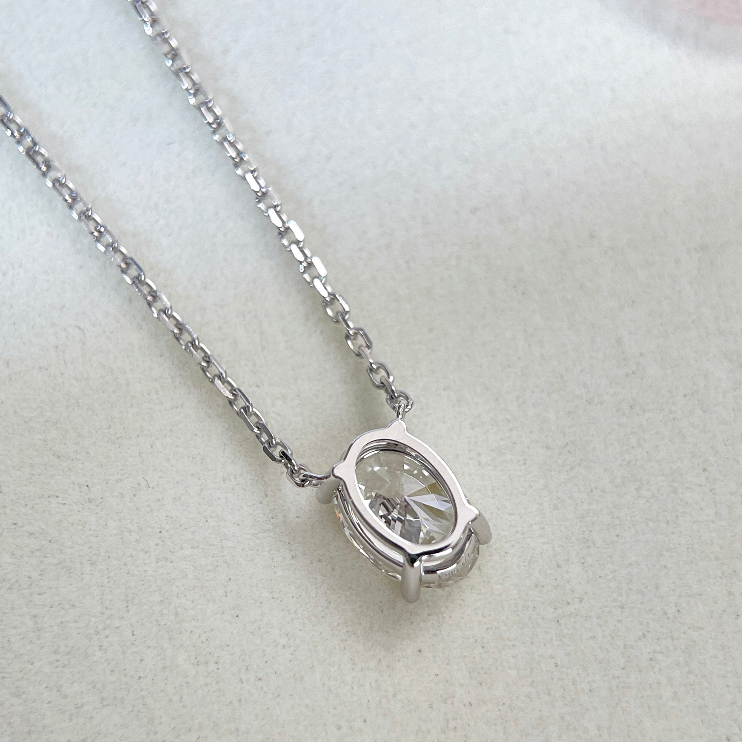 Back view showing the four-prong setting of a 1.58 carat oval lab grown diamond necklace in 18K white gold.