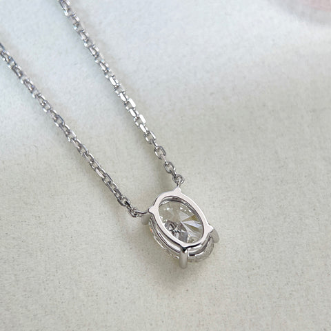 Back view showing the four-prong setting of a 1.58 carat oval lab grown diamond necklace in 18K white gold.