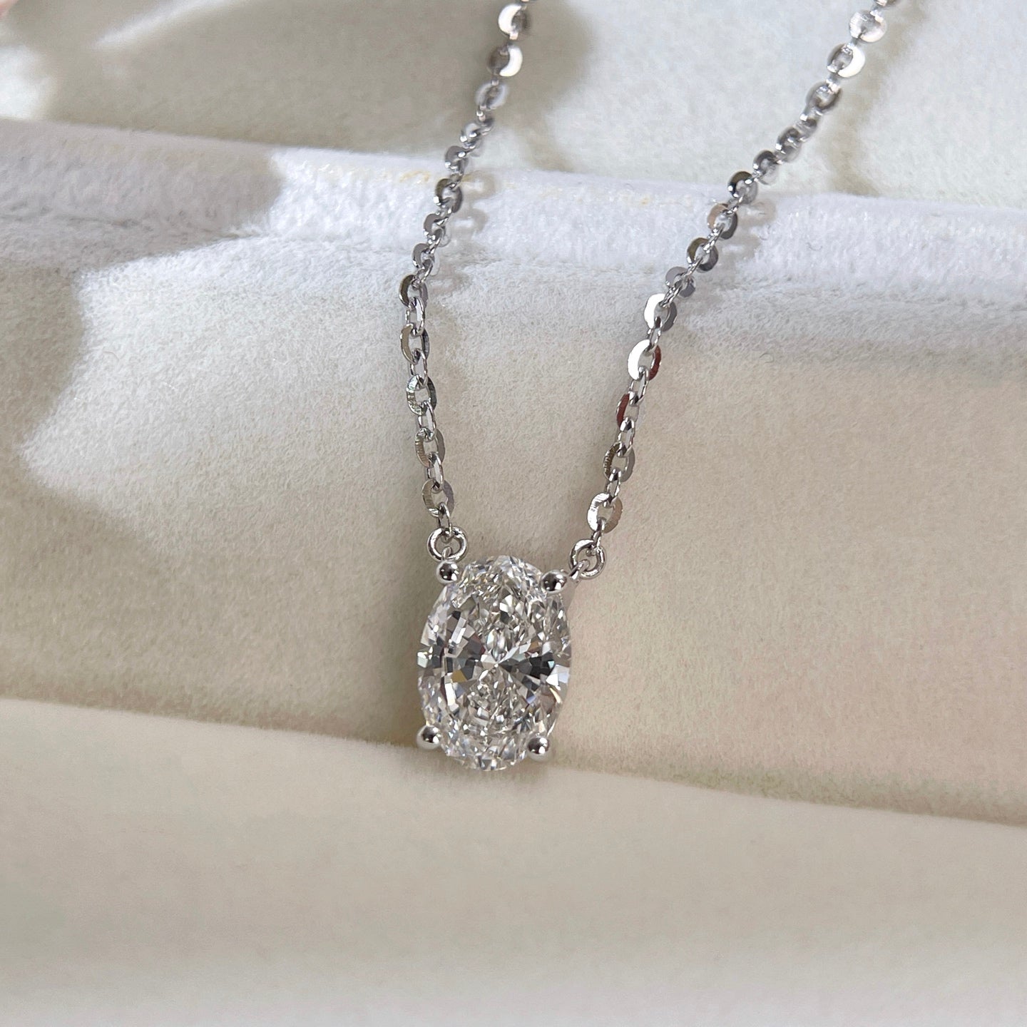 Jewelry display of a 1.5 carat oval lab grown diamond necklace in S925 sterling silver.