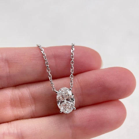 A 1.5 carat oval lab grown diamond necklace in S925 sterling silver displayed on a hand.