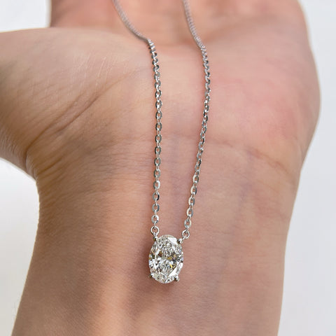 Close-up of a 1.5 carat oval lab grown diamond necklace in S925 sterling silver displayed on a hand.