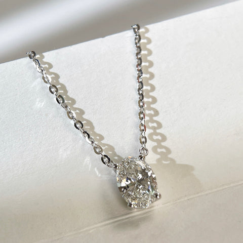 Angled view of a 1.5 carat oval lab grown diamond necklace in S925 sterling silver.