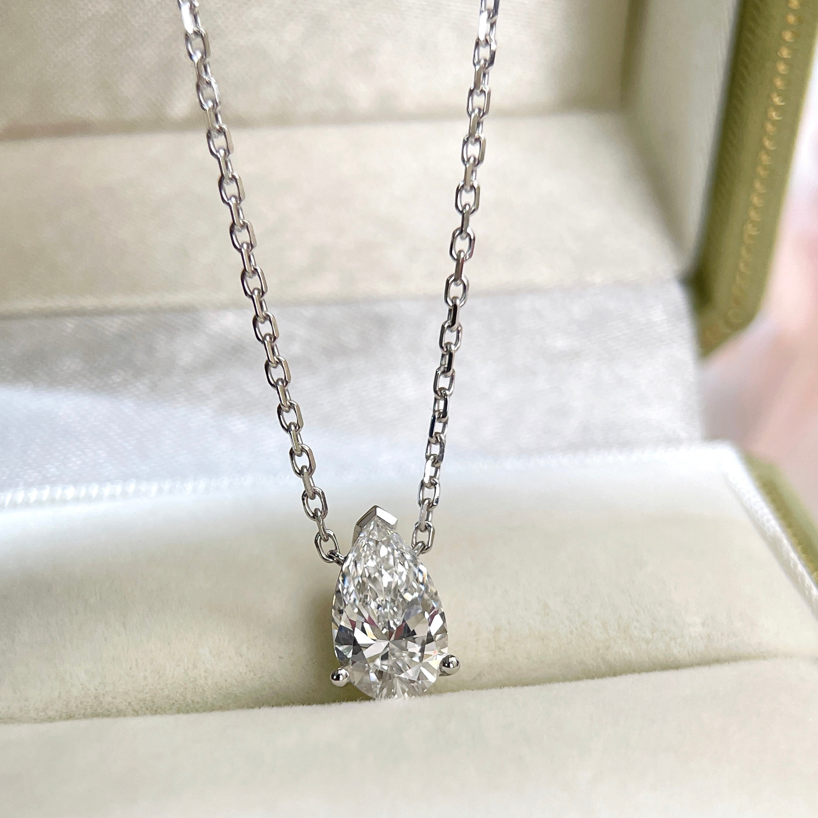 Jewelry display of a 1.5 carat pear lab grown diamond necklace in 18K white gold.