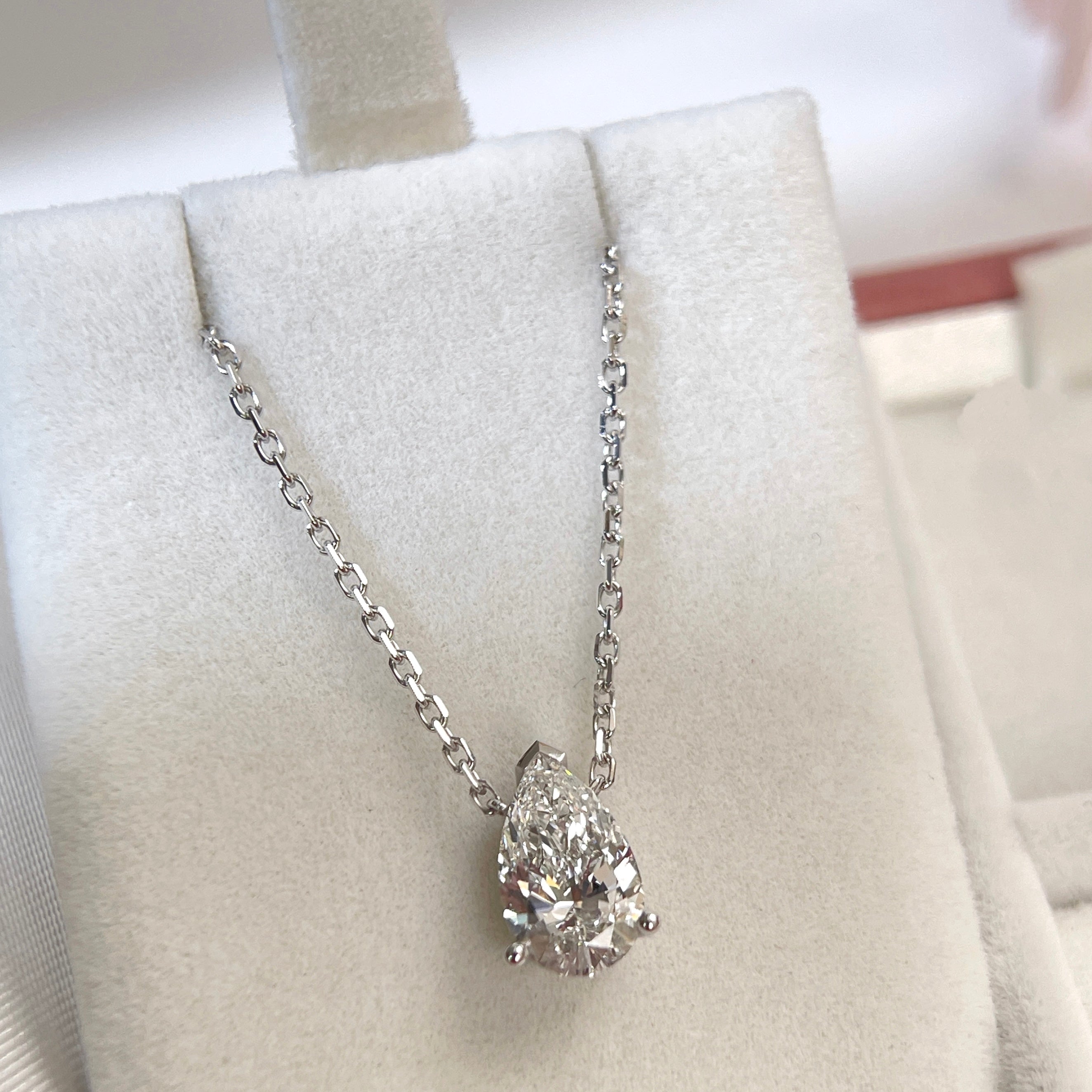 Jewelry display of a 1.5 carat pear lab grown diamond necklace in 18K white gold.