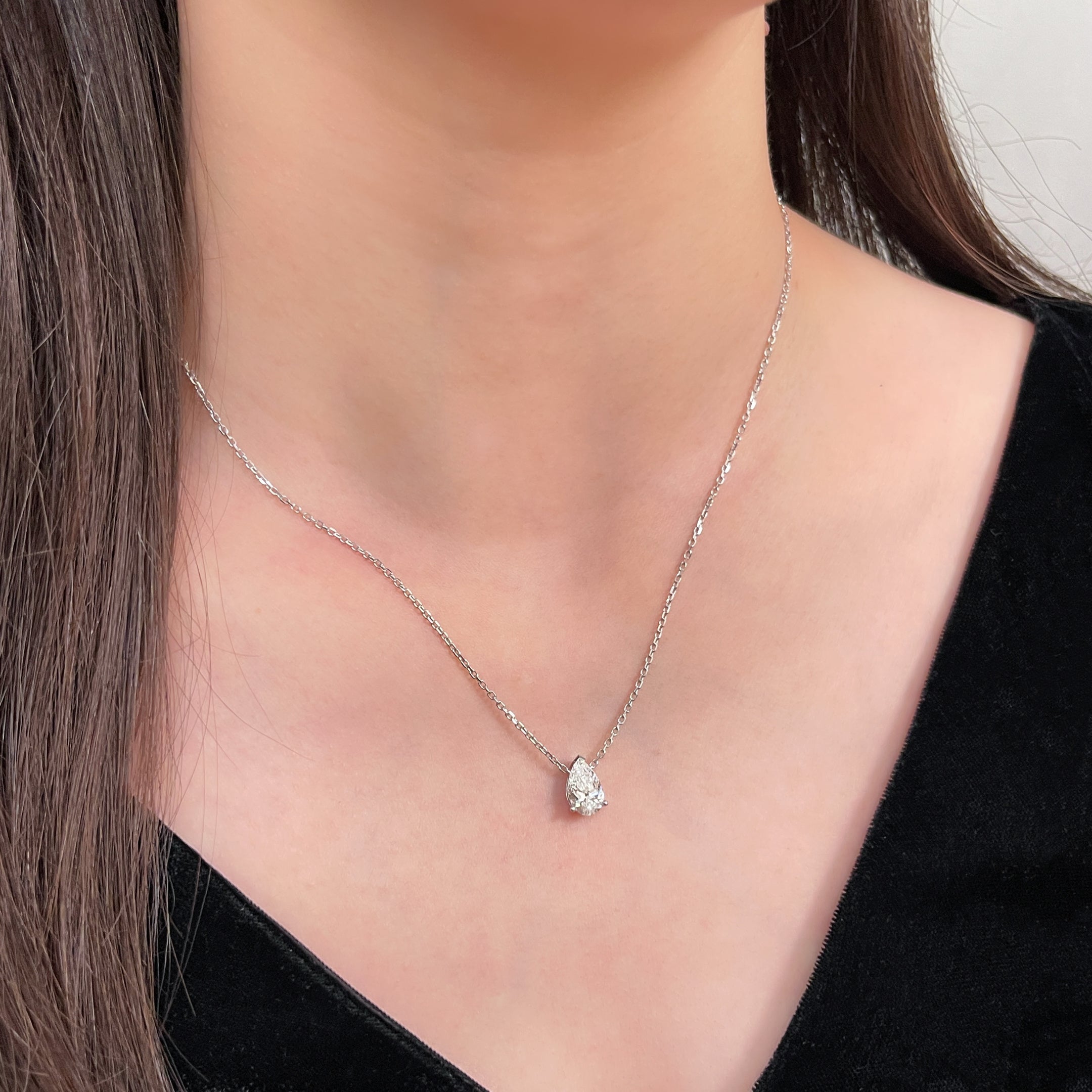 Model wearing a 1.5 carat pear lab grown diamond necklace in 18K white gold.