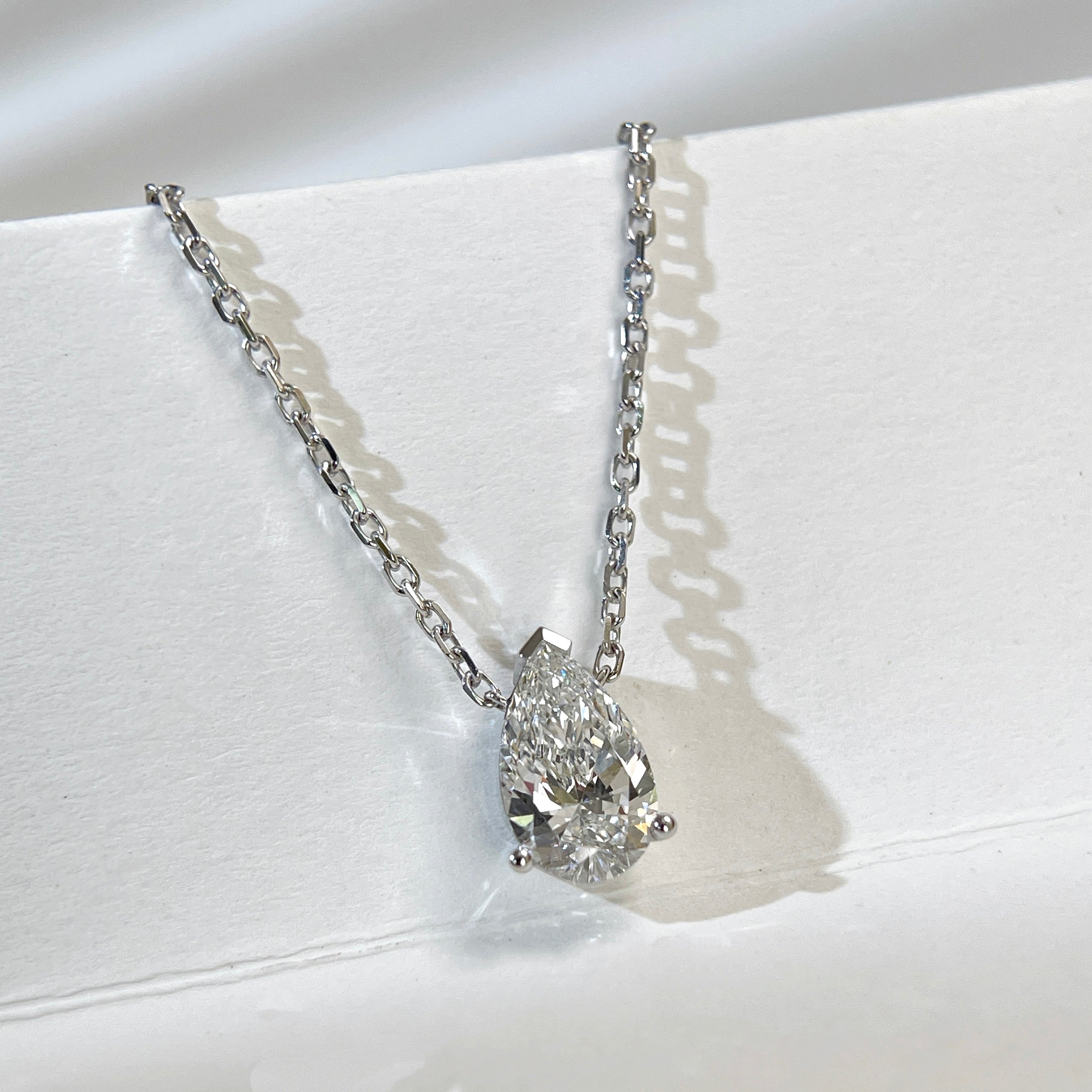 Diamond detail of a 1.5 carat pear lab grown diamond necklace in 18K white gold.