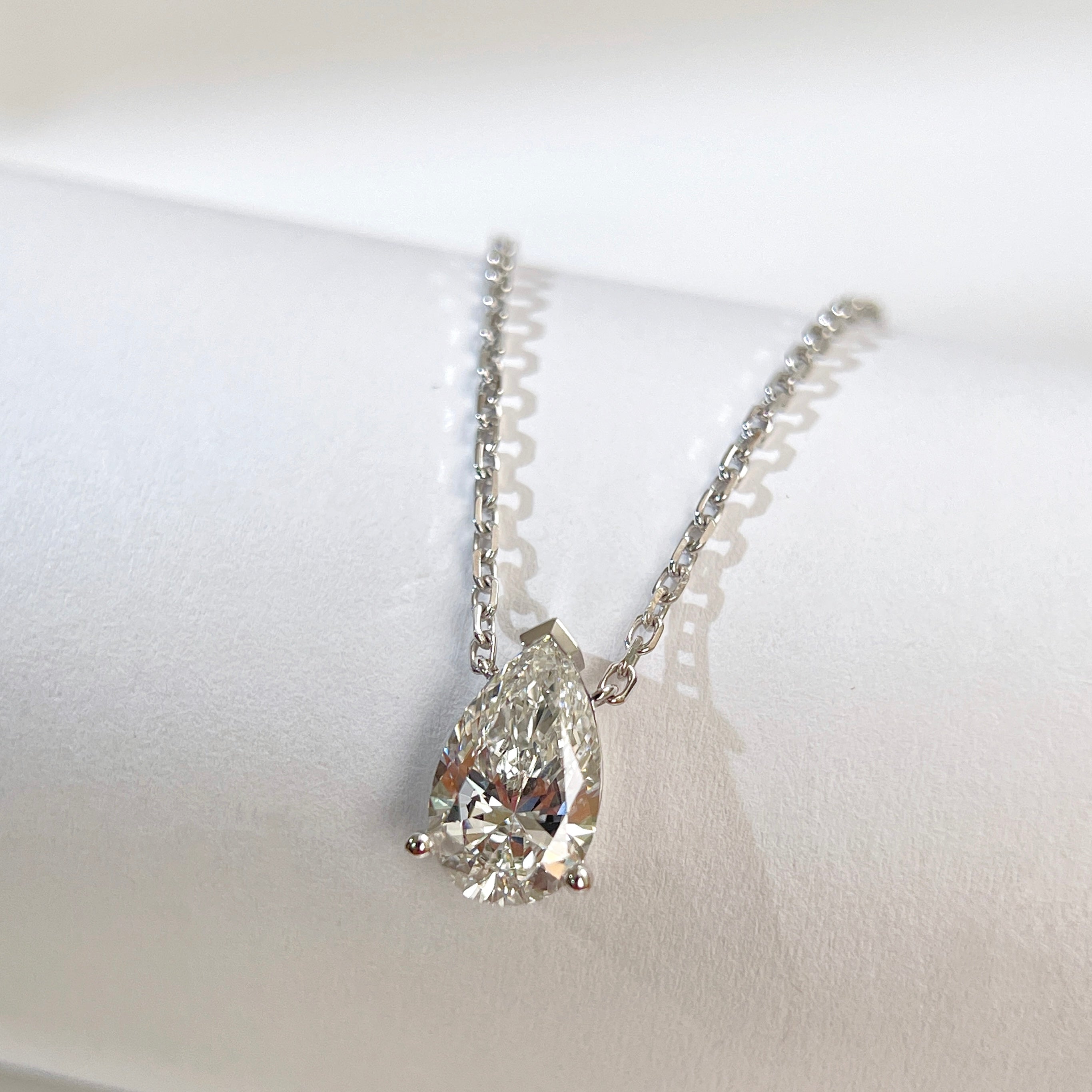 Close-up of a 1.5 carat pear lab grown diamond necklace in 18K white gold.