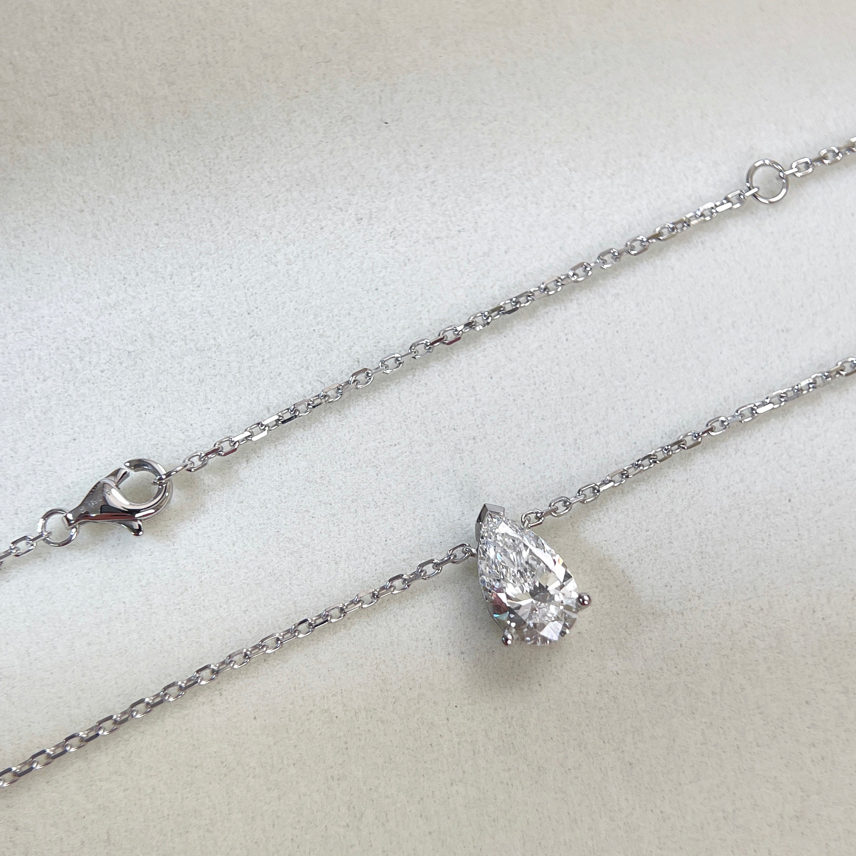 Chain and clasp detail of a 1.5 carat pear lab grown diamond necklace in 18K white gold.