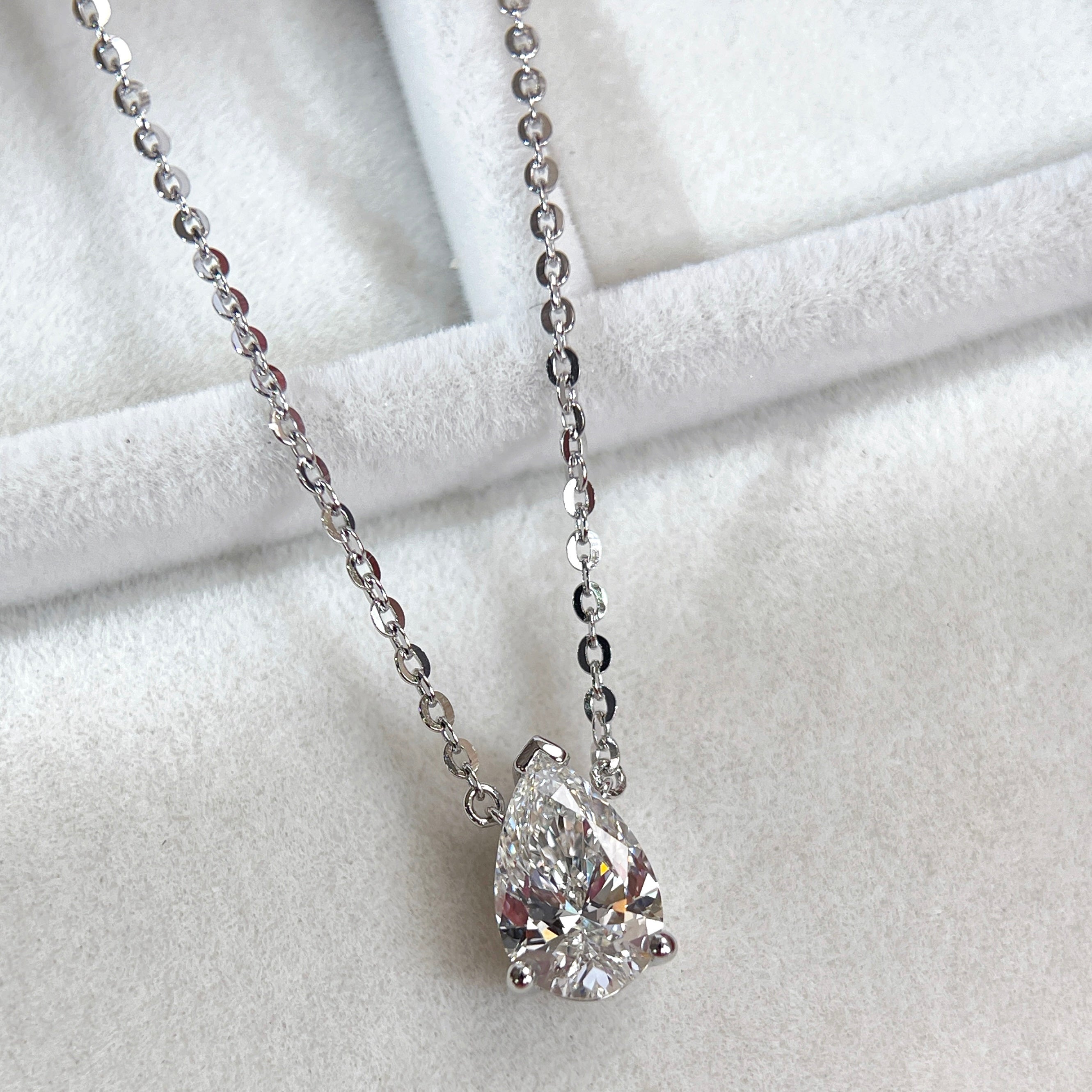 Angled jewelry display of a 1.5 carat pear lab grown diamond necklace in S925 sterling silver.