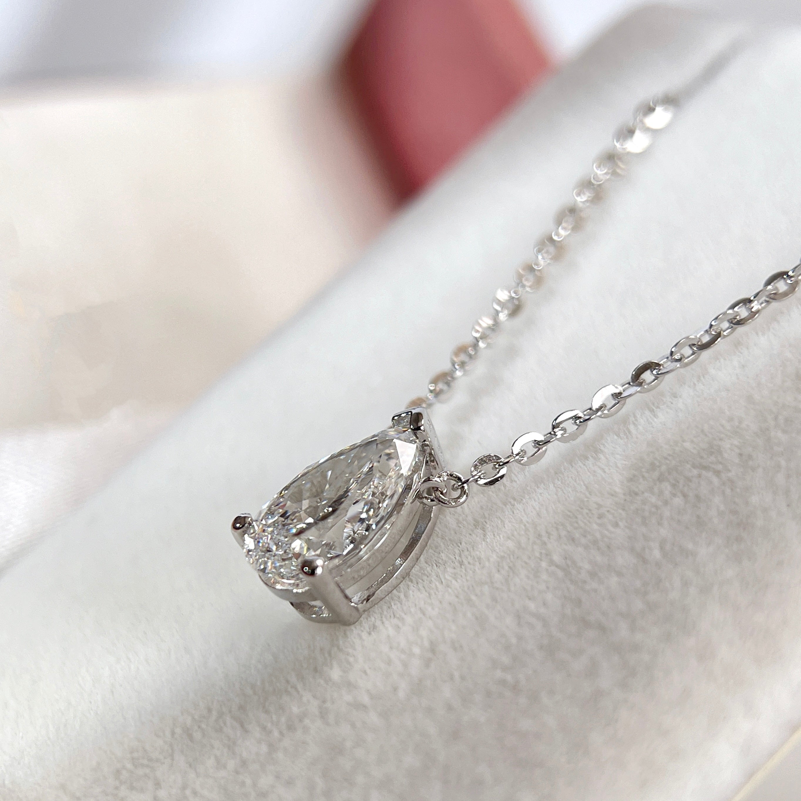 Side view of the three-prong setting of a 1.5 carat pear lab grown diamond necklace in S925 sterling silver.