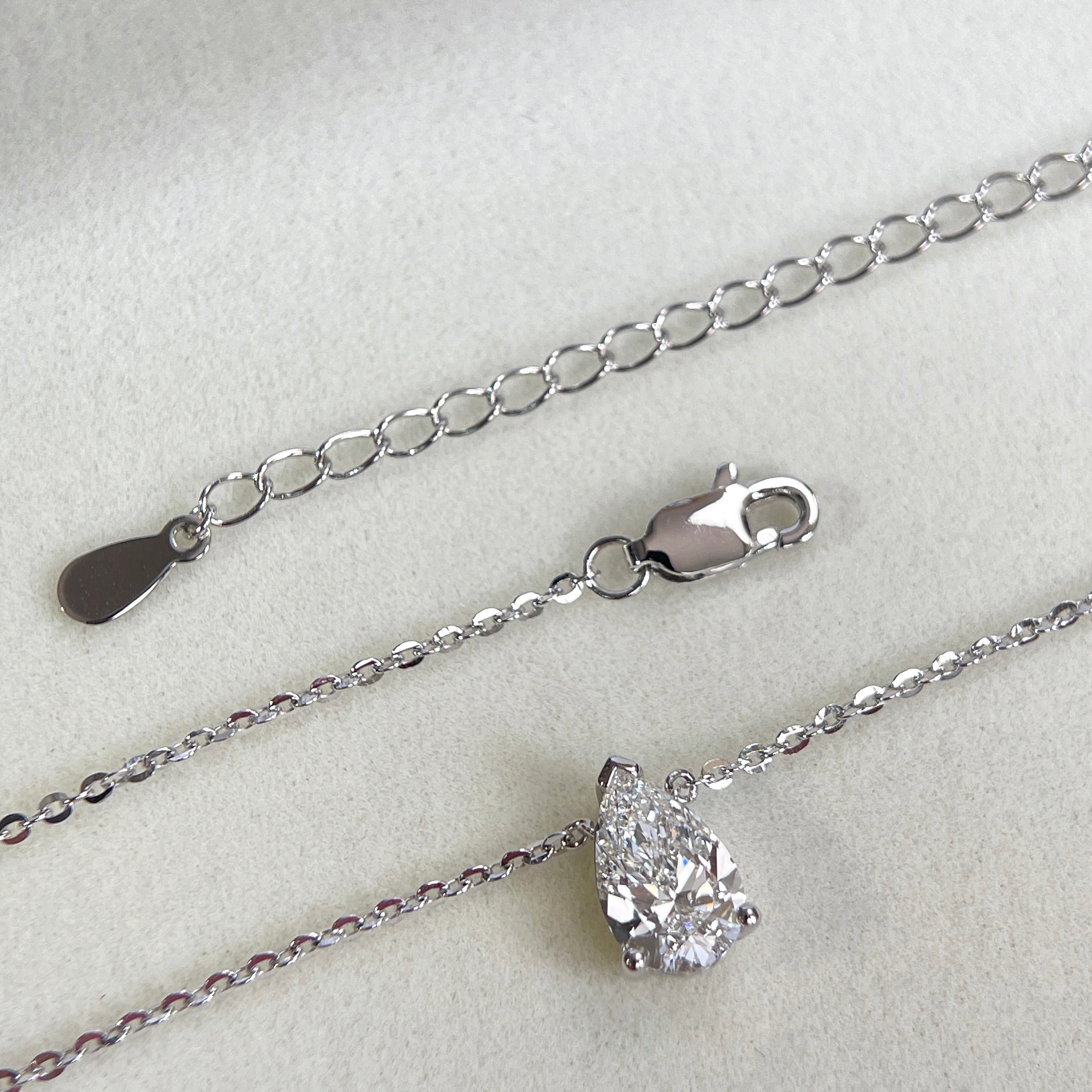 Adjustable extender and clasp detail of a 1.5 carat pear lab grown diamond necklace in S925 sterling silver.