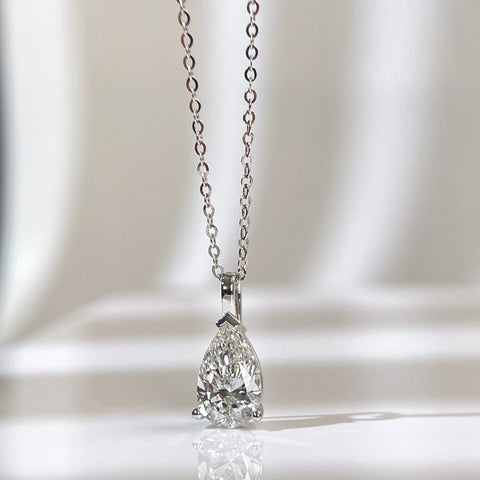 Front view of a 1.5 carat pear lab grown diamond pendant in 14K white gold styled on a chain; chain not included.