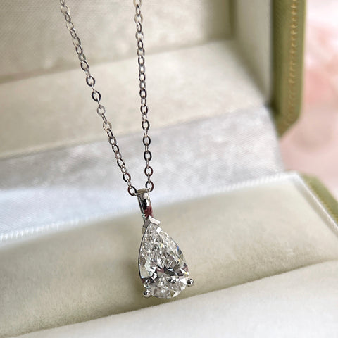Jewelry display of a 1.5 carat pear lab grown diamond pendant in 14K white gold styled on a chain; chain not included.