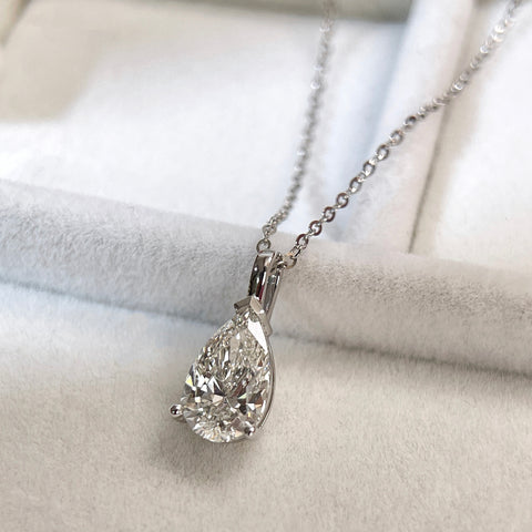 Close-up showing the three-prong setting of a 1.5 carat pear lab grown diamond pendant in 14K white gold styled on a chain; chain not included.