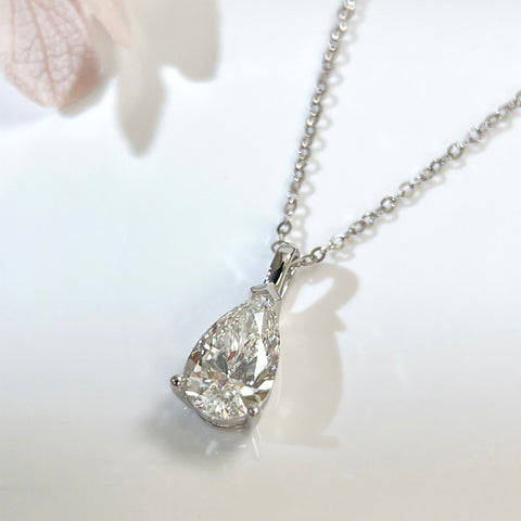 Close-up of a 1.5 carat pear lab grown diamond pendant in 14K white gold styled on a chain; chain not included.