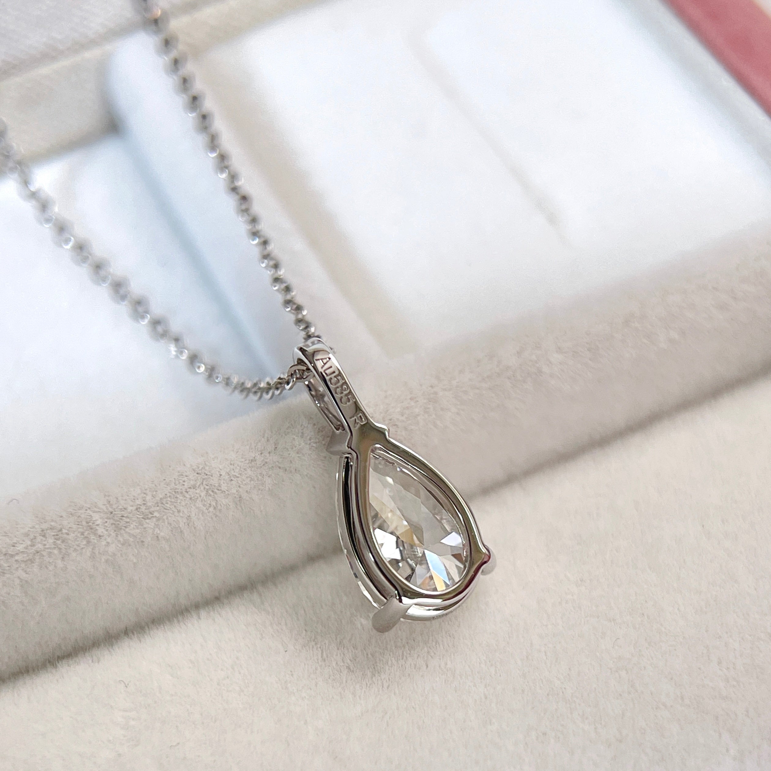 Back view showing the setting of a 1.5 carat pear lab grown diamond pendant in 14K white gold styled on a chain; chain not included.