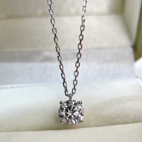 Jewelry display of a 1.5 carat round lab grown diamond fixed pendant necklace in 18K white gold.