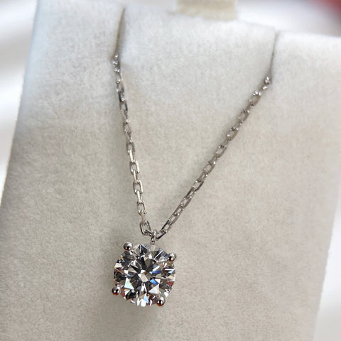 Jewelry display of a 1.5 carat round lab grown diamond fixed pendant necklace in 18K white gold.
