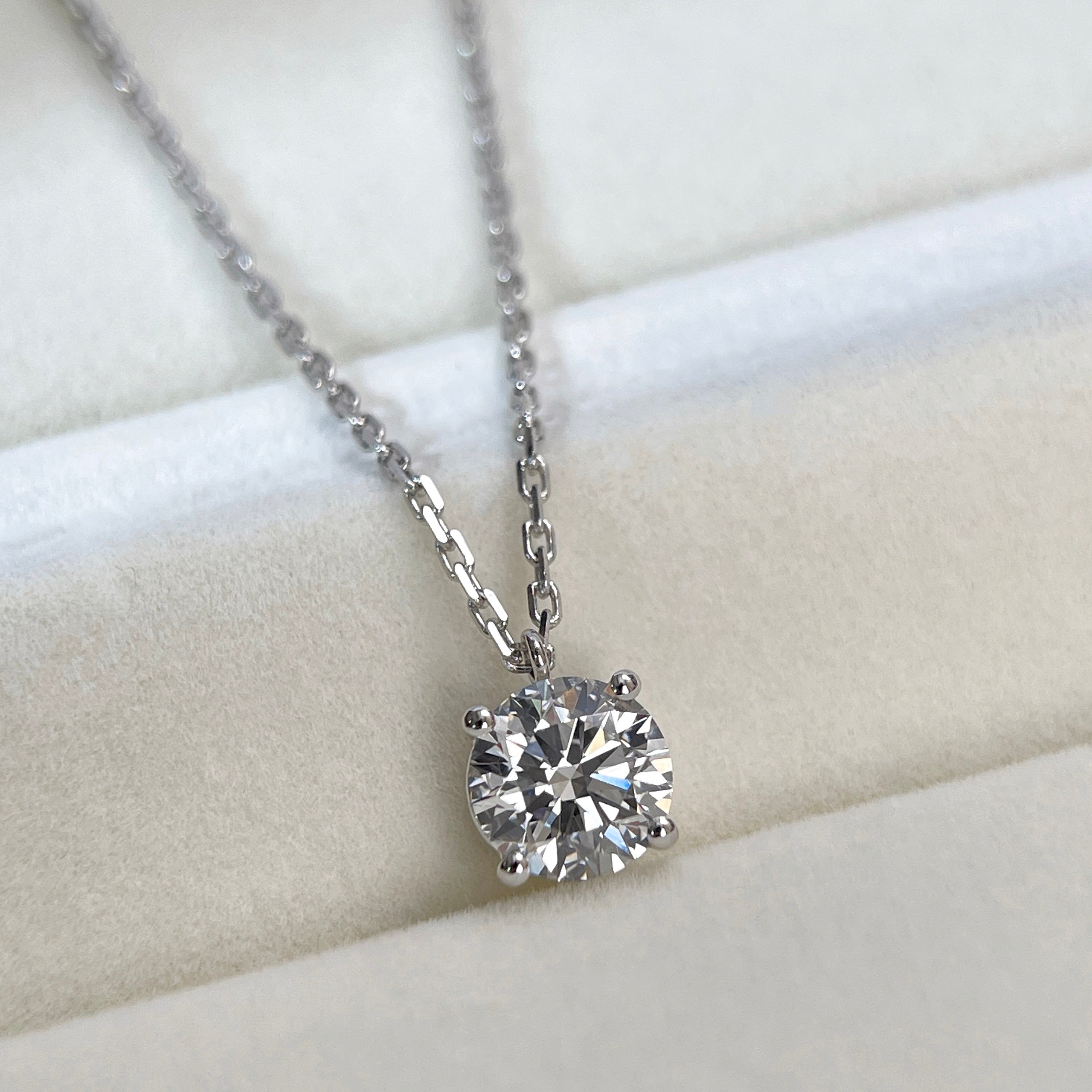 Diamond detail of a 1.5 carat D/VVS2 round lab grown diamond fixed pendant necklace in 18K white gold.