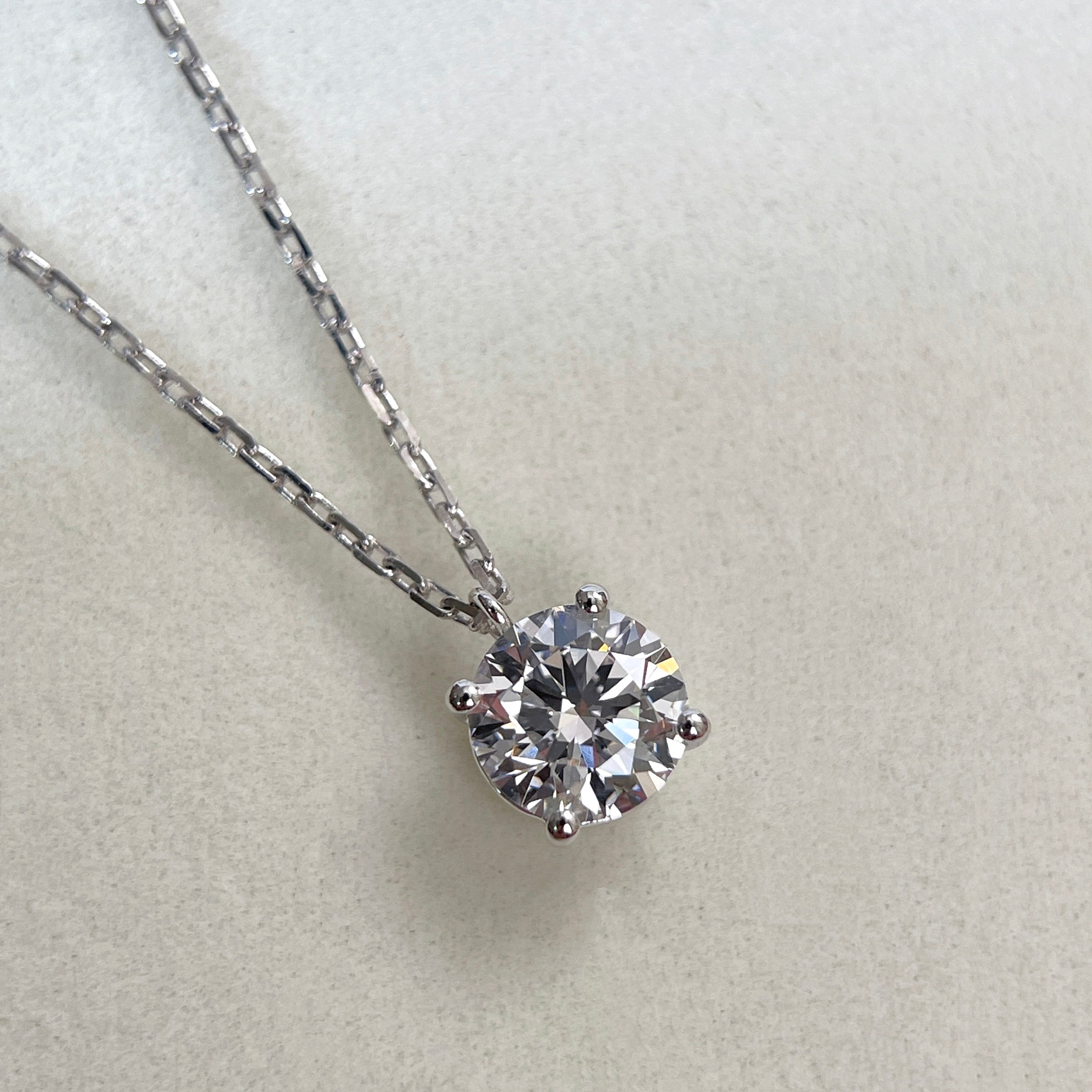 Close-up of a 1.5 carat round lab grown diamond fixed pendant necklace in 18K white gold.