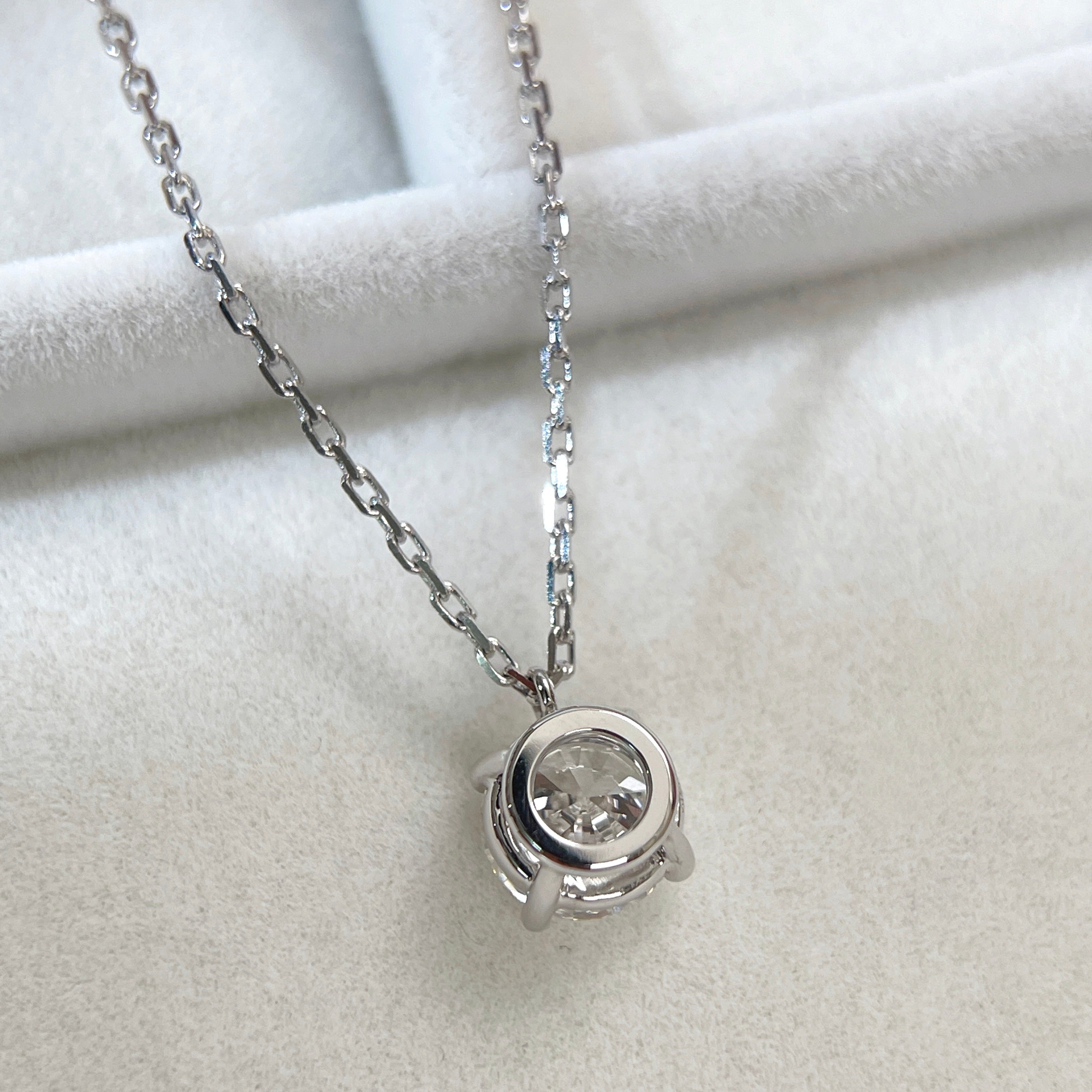 Back view showing the four-prong fixed pendant of a 1.5 carat round lab grown diamond necklace in 18K white gold.