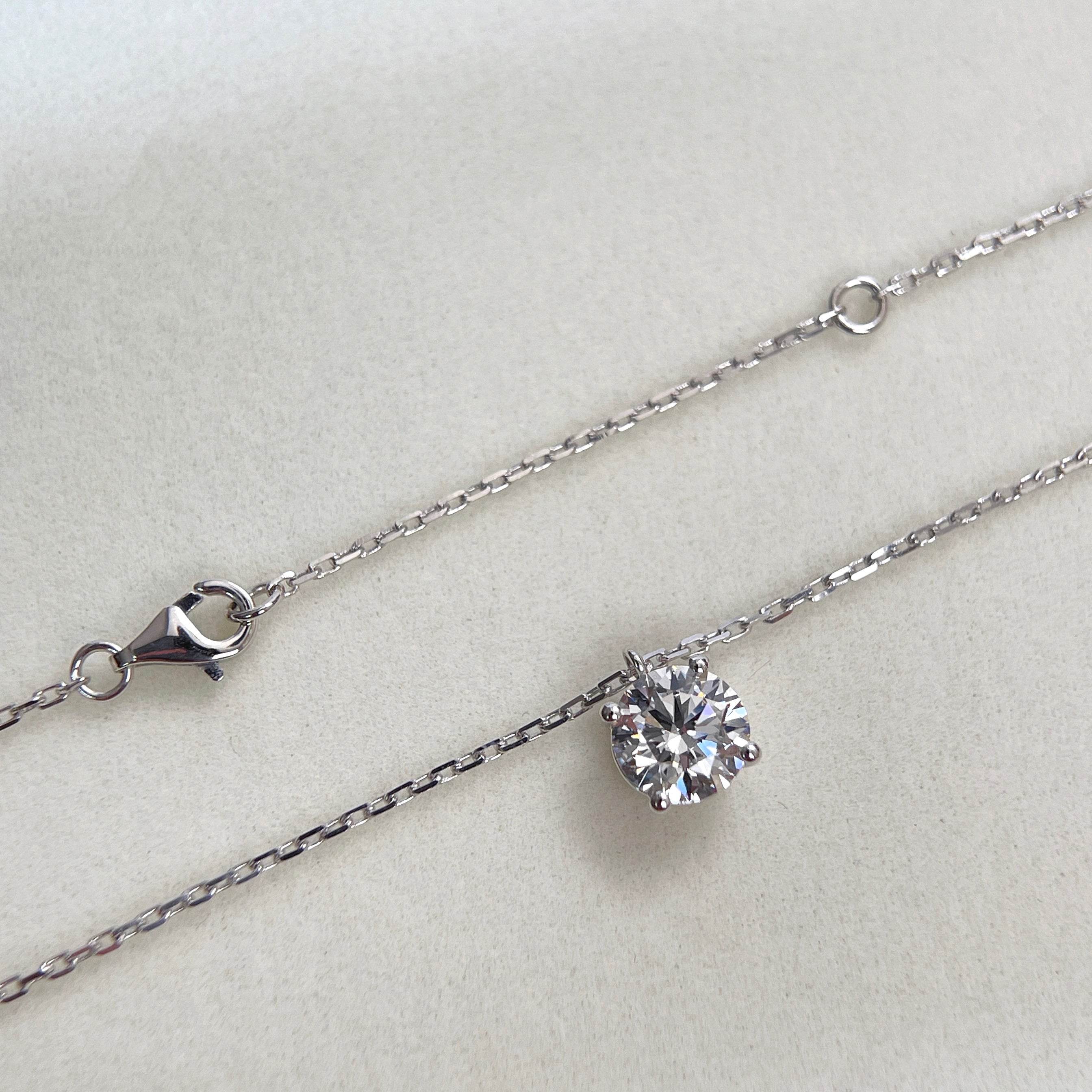 Full view of the substantial square-link chain and lobster clasp on an 18K white gold diamond necklace.