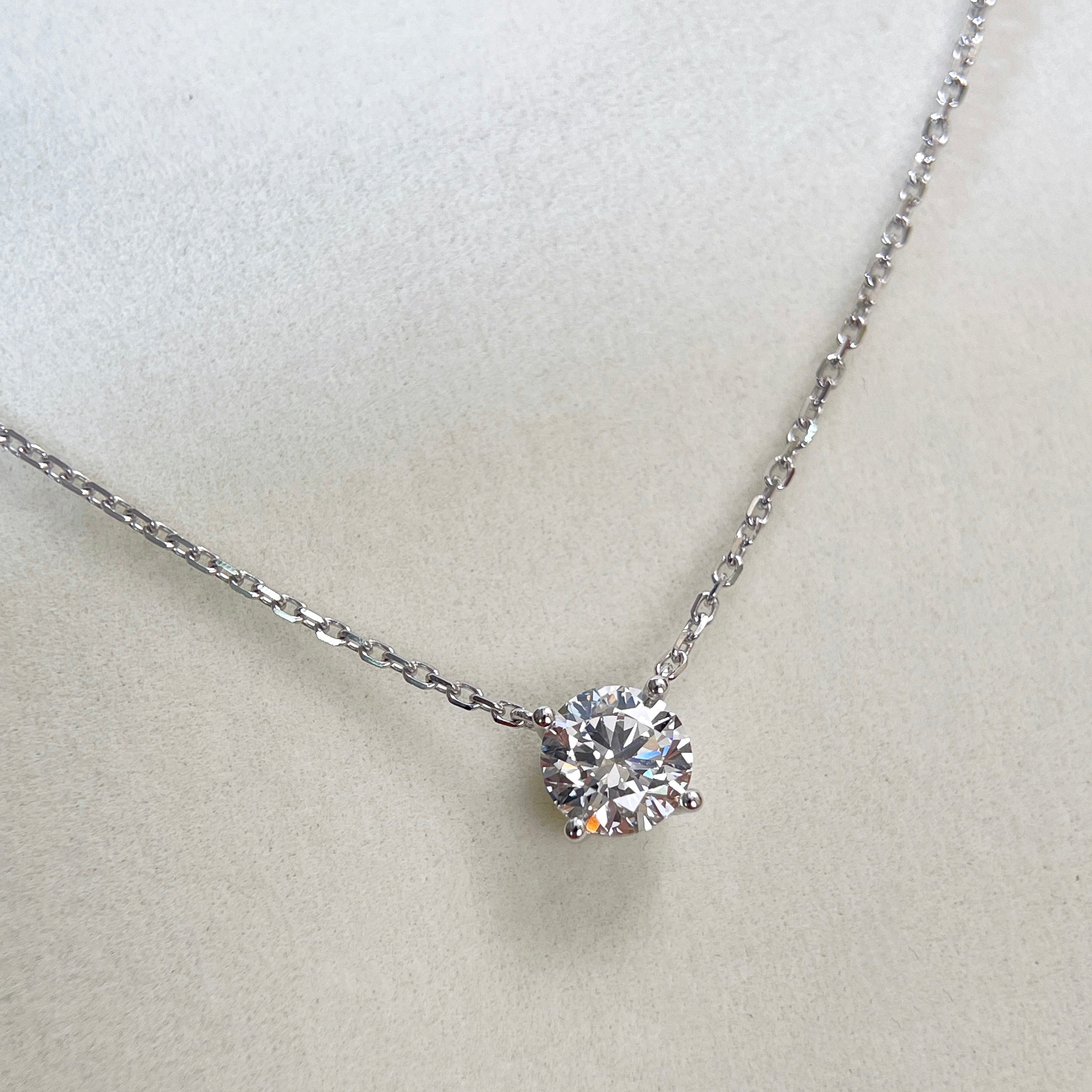 Diamond detail of a 1.5 carat D/VVS2 round lab grown diamond necklace in 18K white gold.