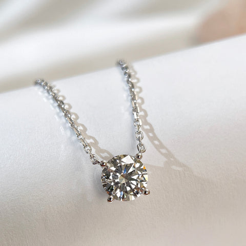 Close-up of a 1.5 carat round lab grown diamond necklace with a fixed pendant in 18K white gold.