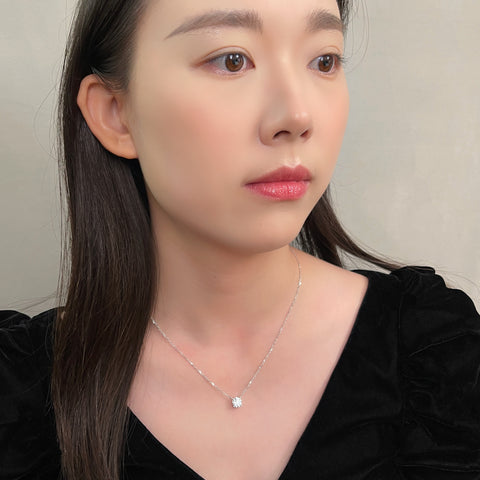 Model wearing a 1.5 carat round lab grown diamond necklace in 18K white gold.