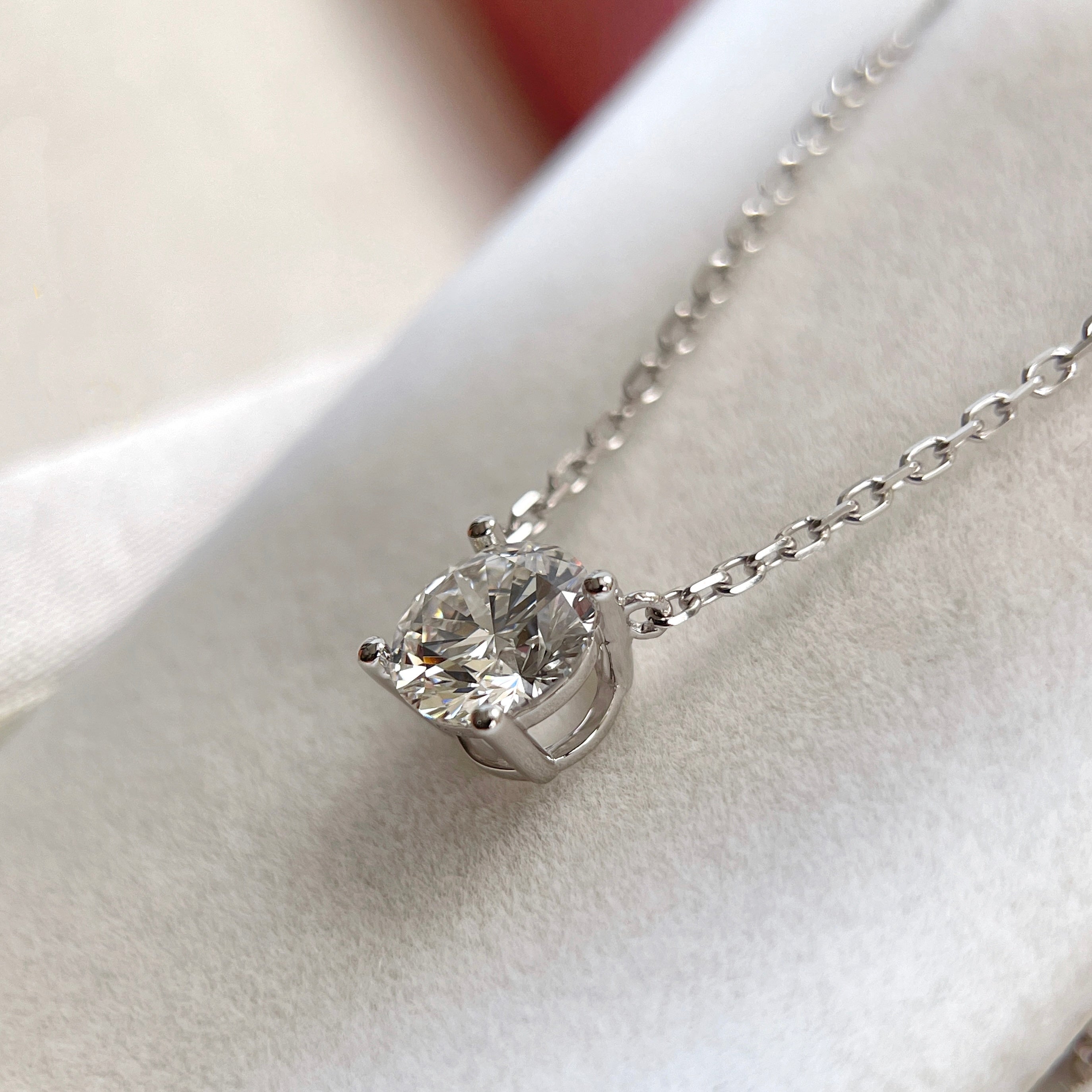 Side view showing the four-prong fixed pendant of a 1.5 carat round lab grown diamond necklace in 18K white gold.