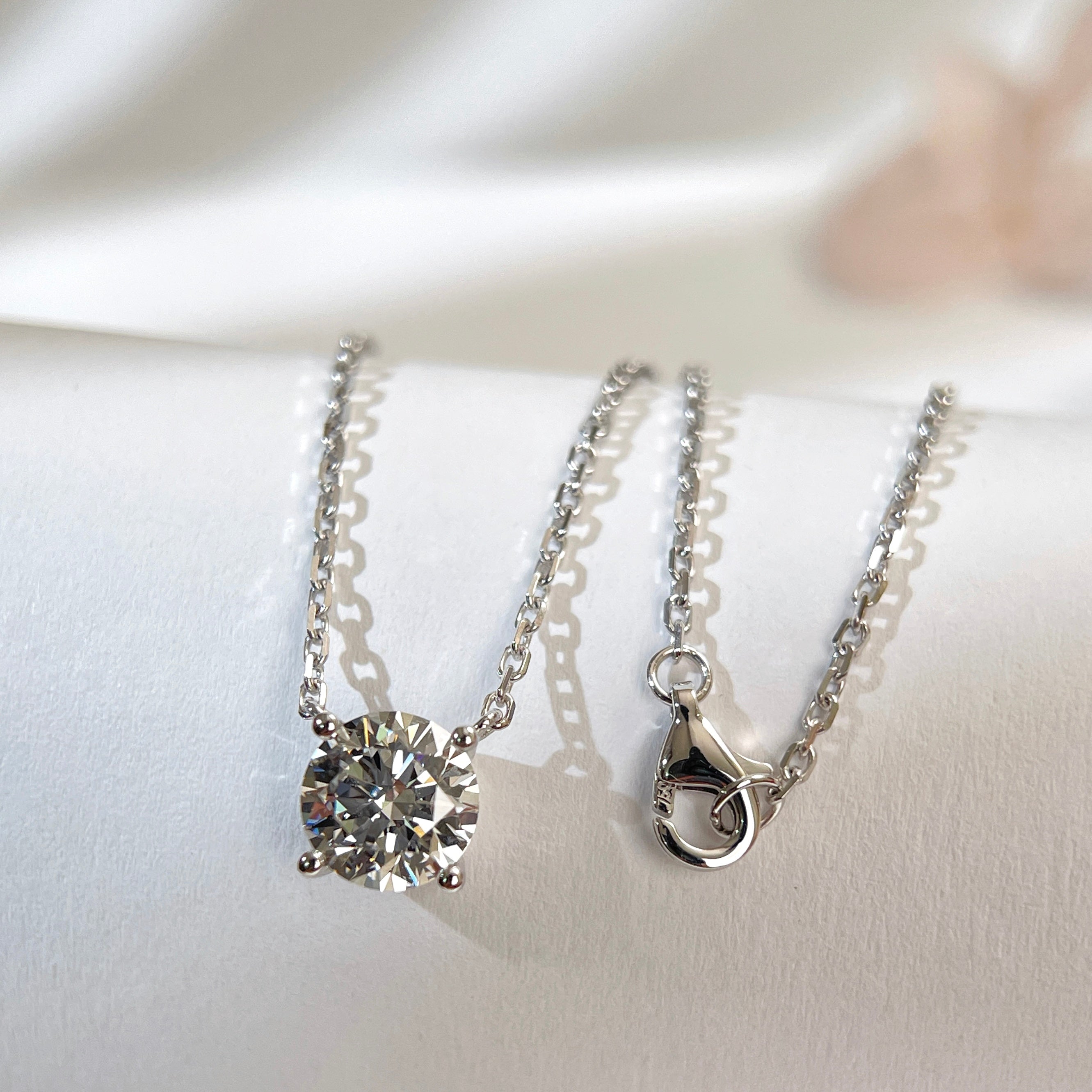 Substantial square-link chain and lobster clasp detail on an 18K white gold diamond necklace.